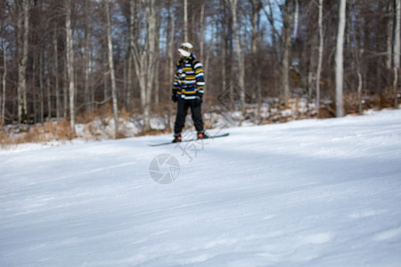 滑雪者带着他的滑雪板路过专注于雪山上的冬季景观图片