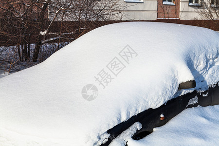 黑车在雪地下关闭在靠近城市图片