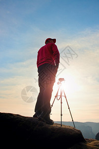 摄影师留在悬崖上的三脚架和思考图片