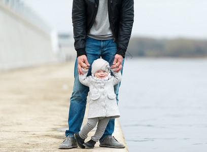 父亲和女儿在河岸边走动图片
