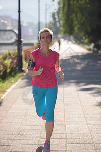 跑步女运动员设置音乐和在智能手机上运行路线图片