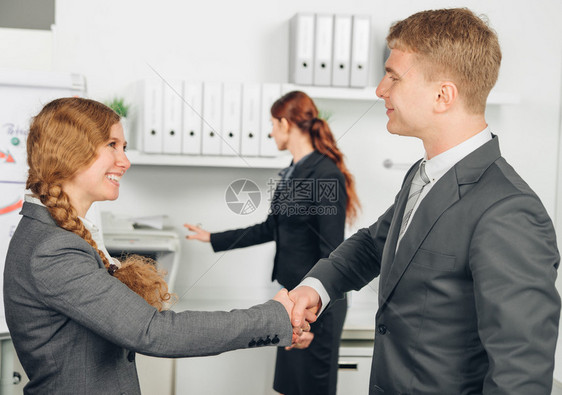 办公室里西装革履的男女握手图片