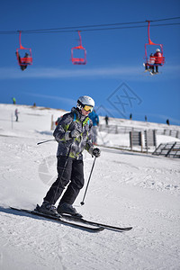 冬季运动青年男子滑雪下山用蓝天空和图片