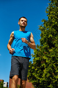 男子跑步运动员在清晨在城市慢跑男子健身日落慢跑锻炼健康概念人面图片