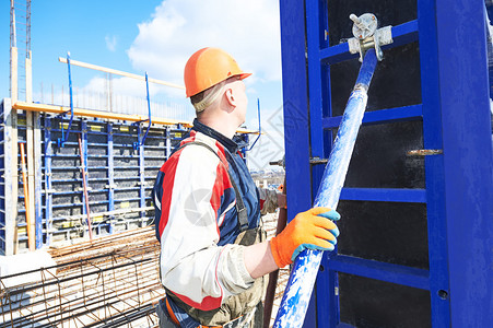 建筑施工人员在建筑工地手持钢管进图片