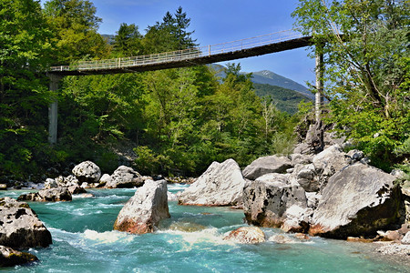 周围有蓝绿色的冷水大石头和森林SocaIsonzo河在斯洛文尼亚图片