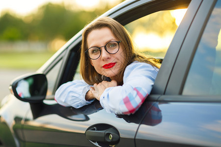 坐在车里的年轻快乐女人购买二手车图片