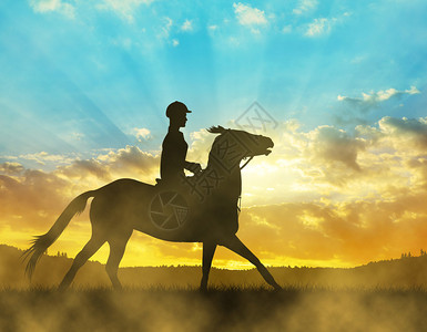 骑马的骑手在日落时的剪影图片