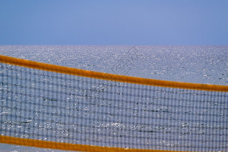 沙滩排球网格在海洋和地平线背景下关图片
