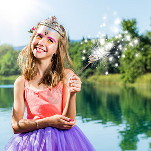 王冠小公主的近距离肖像站在湖边用魔法杖站着女孩用魔背景