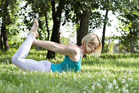 在草地上做瑜伽运动健身健康生活方式的图片