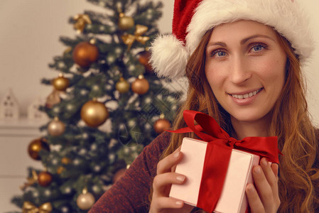 拿着圣诞盒子的女看起来很友好图片