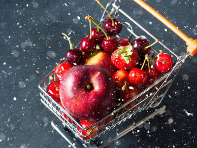 新鲜水果和浆果樱桃子和草莓在黑色背景的超市购图片