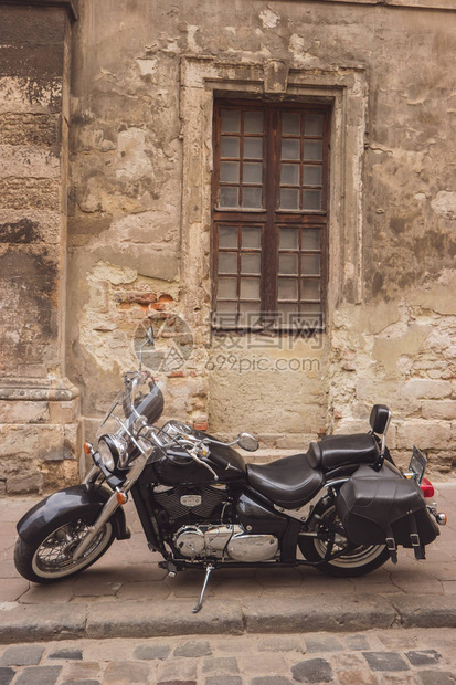 黑色回转摩托车摩托车在旧墙附近图片