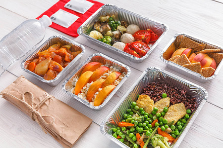 健康的餐厅食物厨师准备饮食每日送餐铝箔盒餐具水和包装中的健身营养蔬菜肉类和水果背景图片