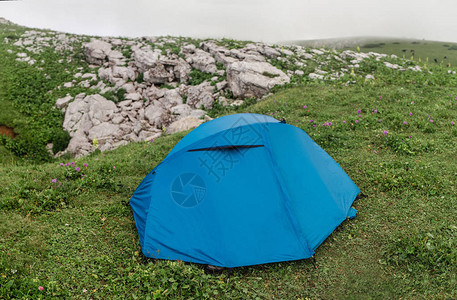 武汉东湖绿道灰色岩石附近绿草地上的帐篷背景
