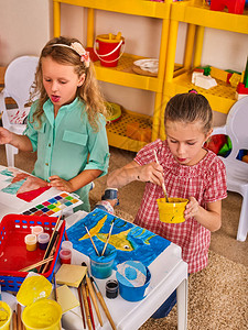 小学生在艺术学校课上画孩子在桌子上用颜料画气球背景上的孩子幼儿园女孩的顶视图绘画教育培养孩图片