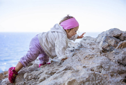 快乐的小女孩在沙滩上攀岩图片