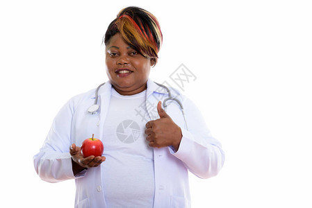 电影演播室的一拍快乐的非洲胖黑人女医生笑着微笑同时握着红苹图片