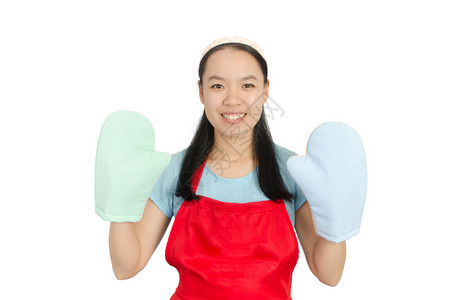 身着红围裙和烤炉手套的亚洲青年妇女准备做饭或烘图片