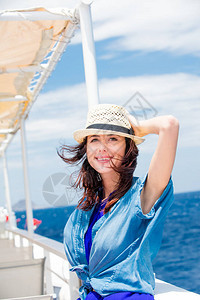 希腊大海背景前船上美丽年轻女子的照片图片