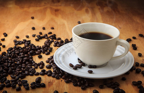 黑咖啡和咖啡豆在木纹理背景早背景图片