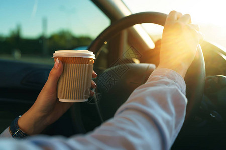 喝咖啡去开车的年轻女人图片