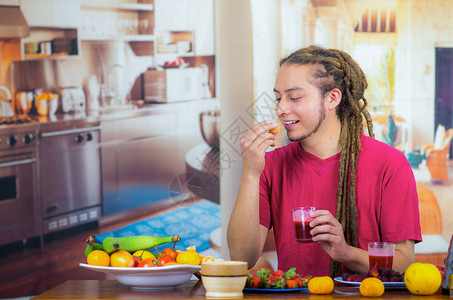 带着恐惧的年轻人享受健康早餐吃水果喝冰淇淋和微笑家居厨图片