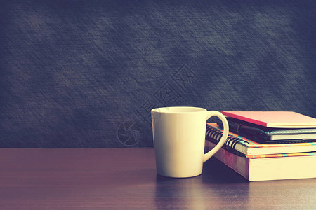 咖啡杯和篮板背景的木桌上的笔记本图片