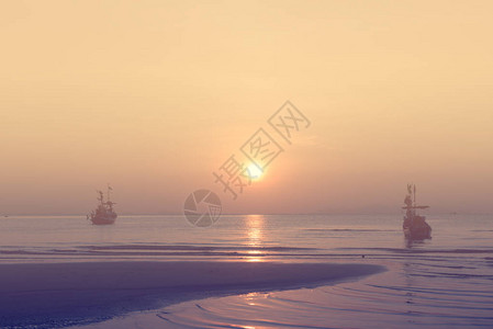 海洋和天空的金色日落渔船漂浮图片