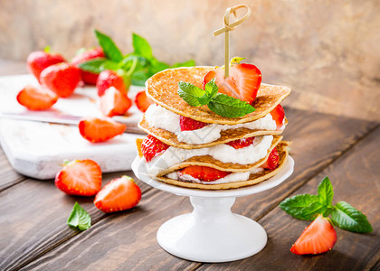 薄饼和酸奶和草莓在白瓷蛋糕摊上儿童党的概念背景图片