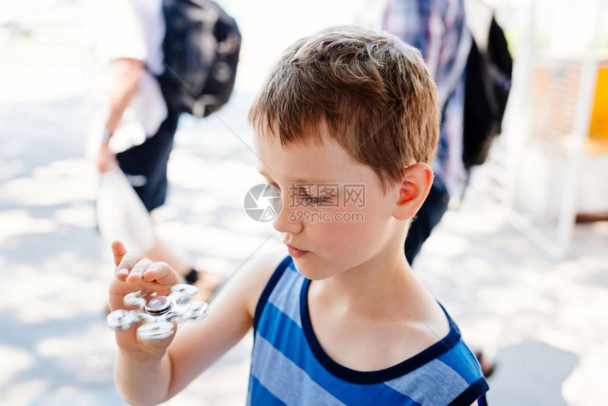 小男孩在户外玩指尖陀螺图片