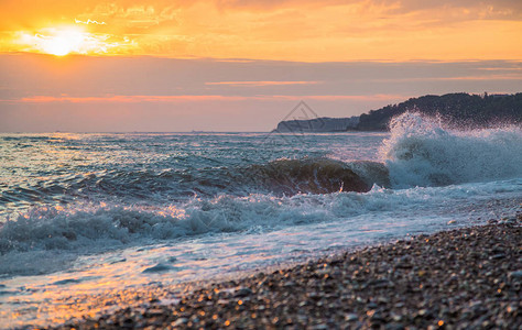 夕阳下沙滩上汹涌的海浪图片