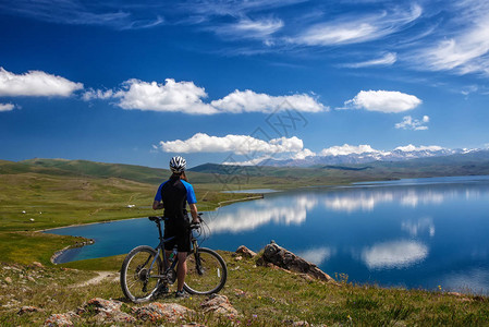 一个年轻男子骑着自行车在高山湖SongK图片