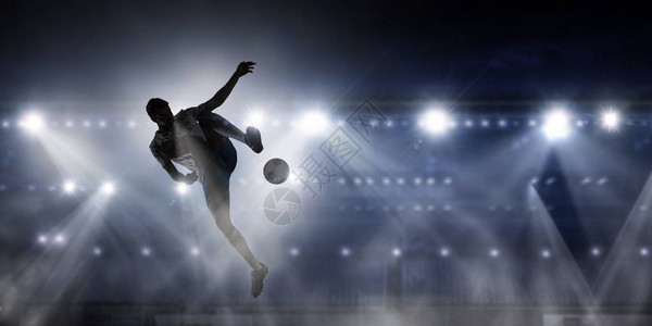 足球运动员在体育场跳球踢的休维特Sillh图片