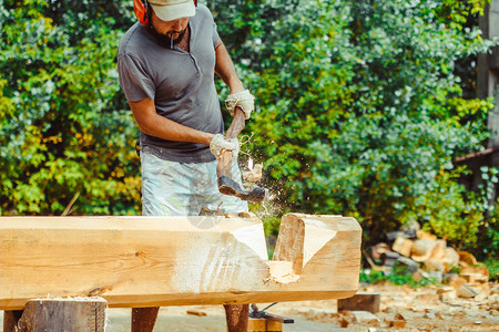 一个强壮男人用把木头砍碎的手集中在斧子上当它分背景图片
