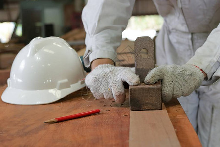 工人在木工车间用手工刨木板的手图片