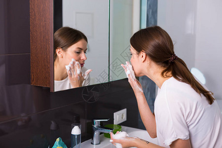 洗脸泡沫女人早上用泡沫清洁剂洗脸背景
