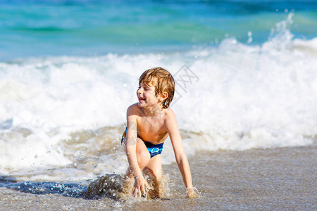 在佛罗里达州的海滩上玩的小金发孩子男孩高清图片