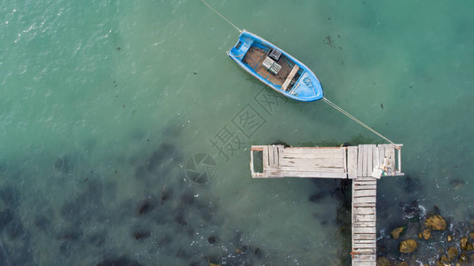 绿松石海洋中的孤独渔船和木墩空中照片俯视图图片