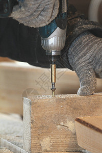 木工用螺丝刀拧紧木制木板上的螺钉图片