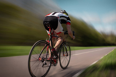 男骑自行车的头盔和运动服骑脚踏车后视图图片