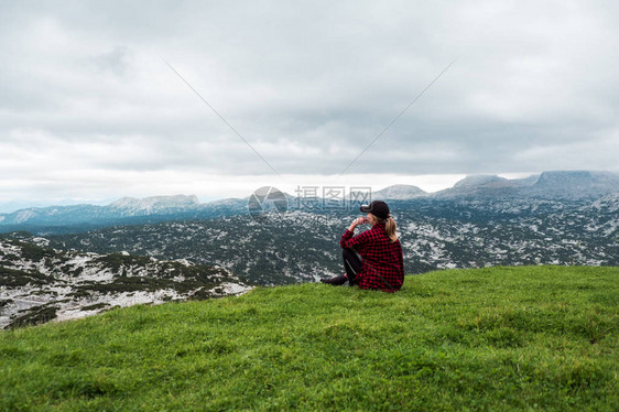 阿尔卑斯山草甸欣赏山景的年轻女子图片