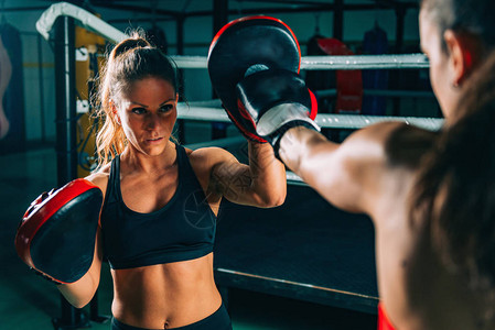 体育锻炼两个女人在健身房拳击训练的肖像背景