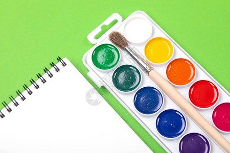 水彩油漆箱彩色涂料和绿色背景的油漆刷子图片