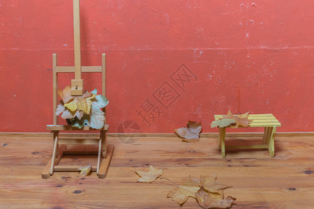 用干叶小木凳和木地板上的干叶以及制片厂的红漆墙上的传统斜坡站立图片