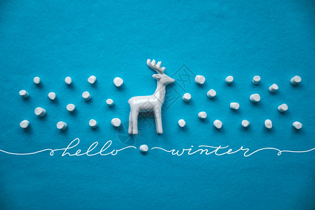你好冬季概念创意成分与驯鹿和装饰蓝底棉花糖雪的背景图片