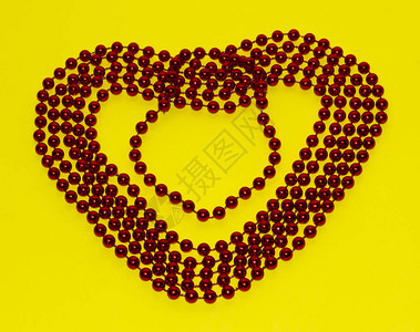 白底红色玻璃珠黄色背景上的红色玻璃珠串珠宝概念选择焦点图片