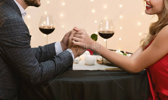 情侣在餐厅牵手浪漫约会的特写镜头图片