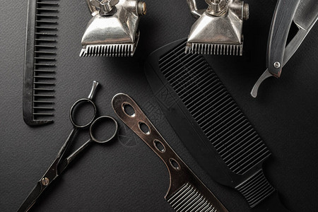 黑色的表面上是旧的美发师工具两把老式手持式理发剪梳子剃须刀美发剪刀剃须刷黑色单水平方向图片